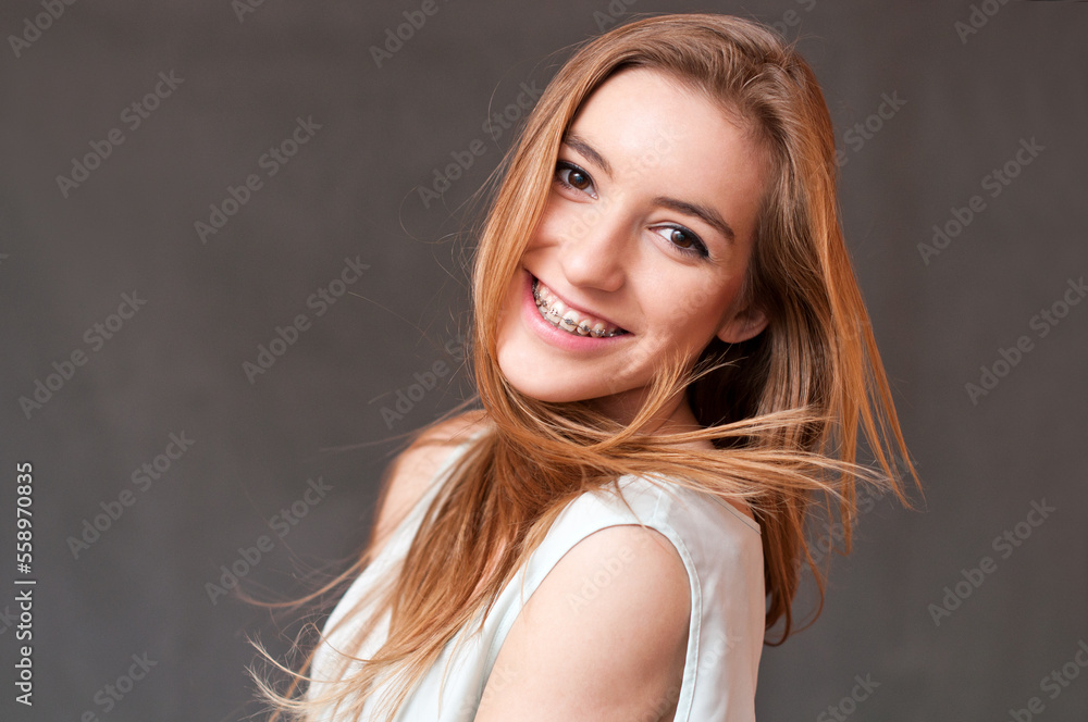 Fototapeta premium Smiling girl wearing braces on straight teeth