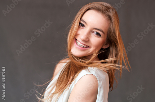 Smiling girl wearing braces on straight teeth