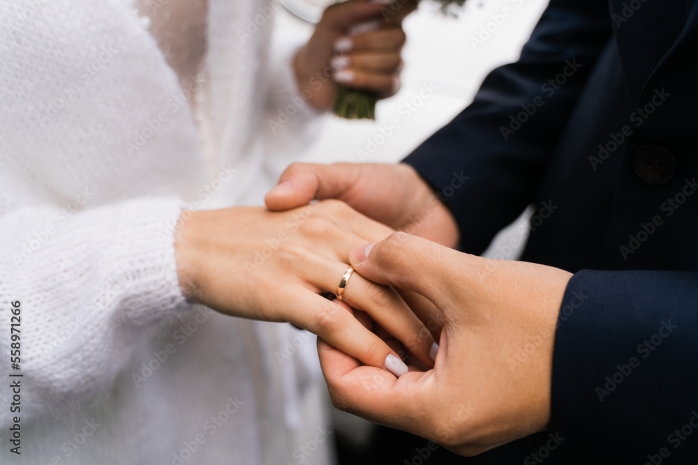 Obraz premium the groom puts on the ring to the bride, close-up