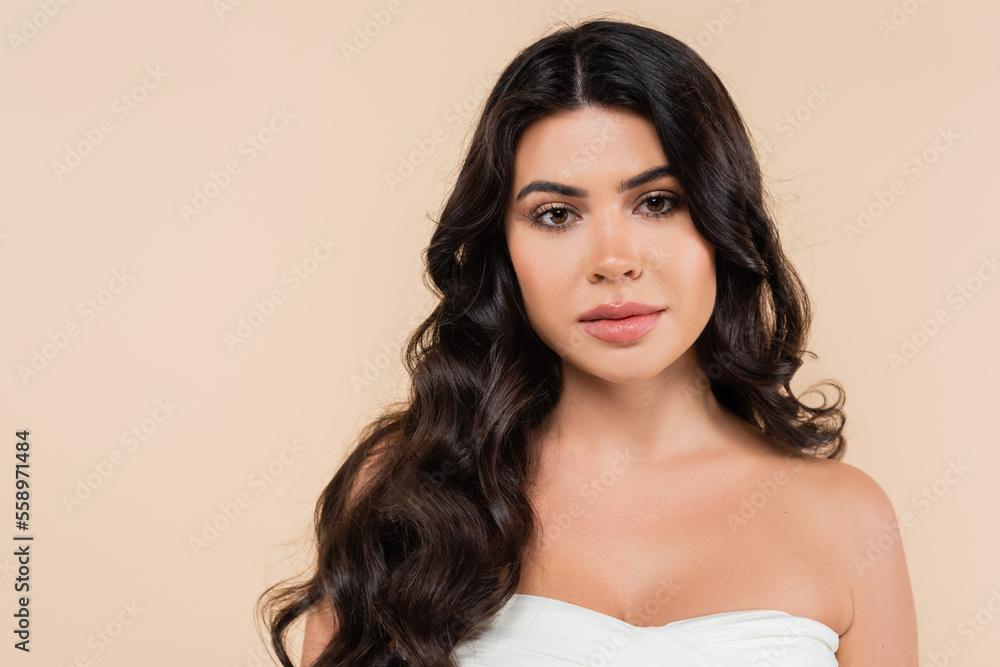 Portrait of woman with wavy hairstyle looking at camera isolated on beige. Portrait of woman with wavy hairstyle looking at camera isolated on beige.