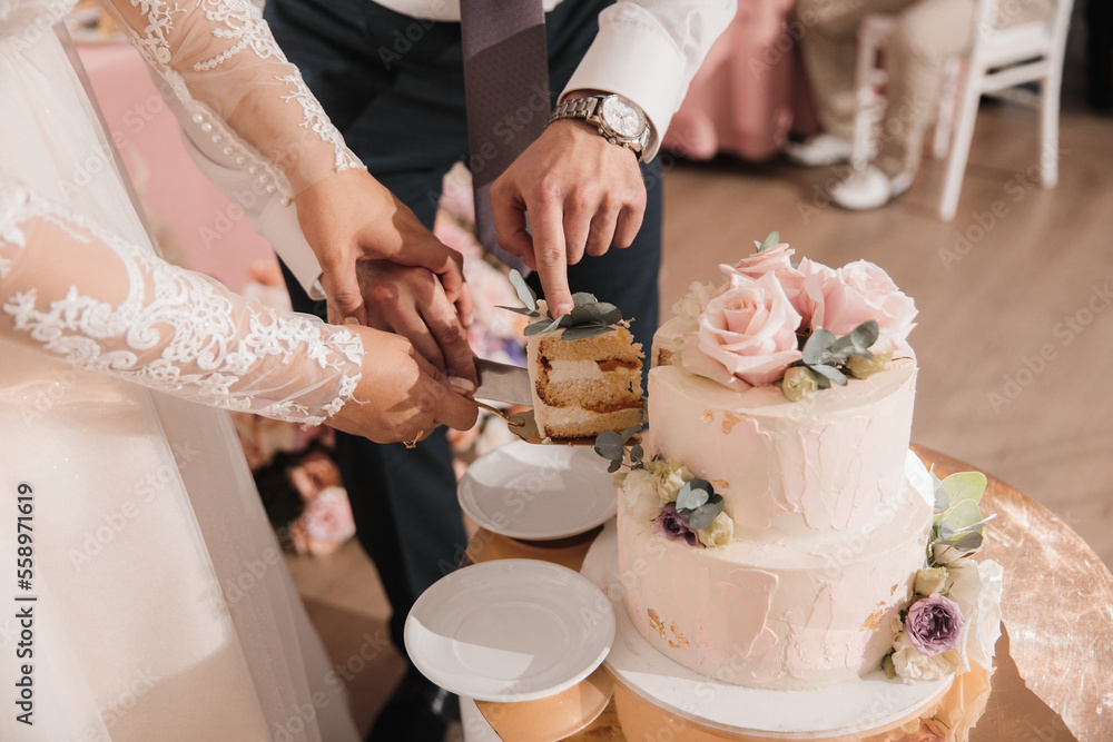 Newlyweds cut the first piece of wedding cake at their wedding Newlyweds cut the first piece of wedding cake at their wedding
