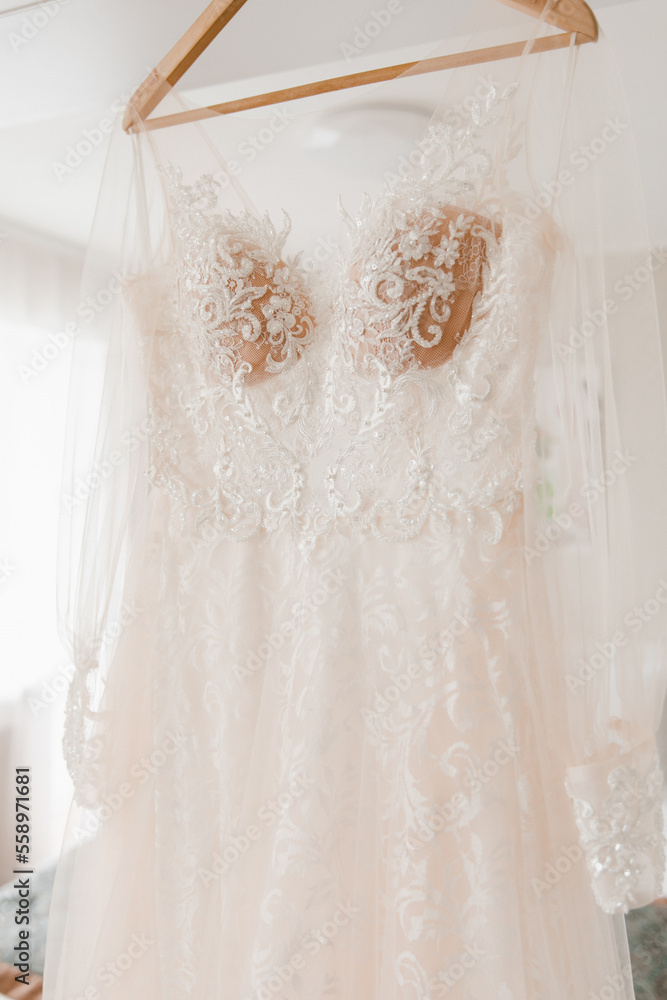 wedding dress close-up hanging in a light interior wedding dress close-up hanging in a light interior