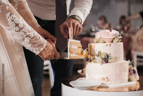 Newlyweds take off the first cut piece of the wedding cake