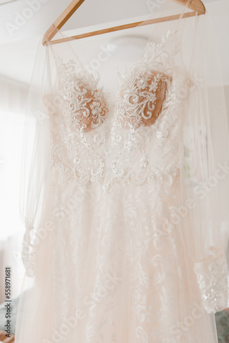 wedding dress close-up hanging in a light interior