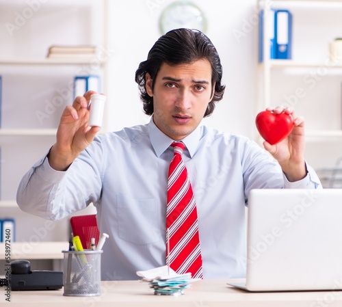 Young male employee suffering in the office