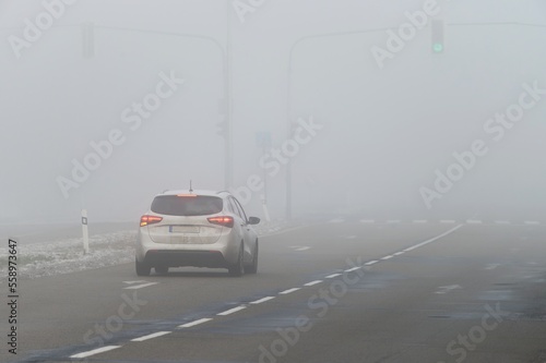 Cars in the fog. Bad winter weather and dangerous automobile traffic on the road. Light vehicles in fog. © montypeter