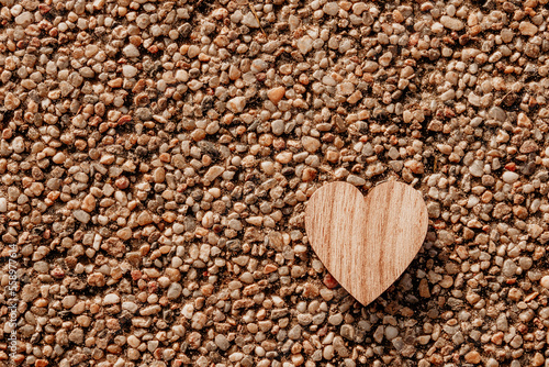 wooden valentine's heart on pebbles