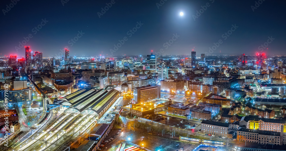 Naklejka premium Manchester City Centre. Aerial view of Picadilly train station Manchester City Centre and construction and redevelopment work at dawn with city lights and dark skies of this English city. 