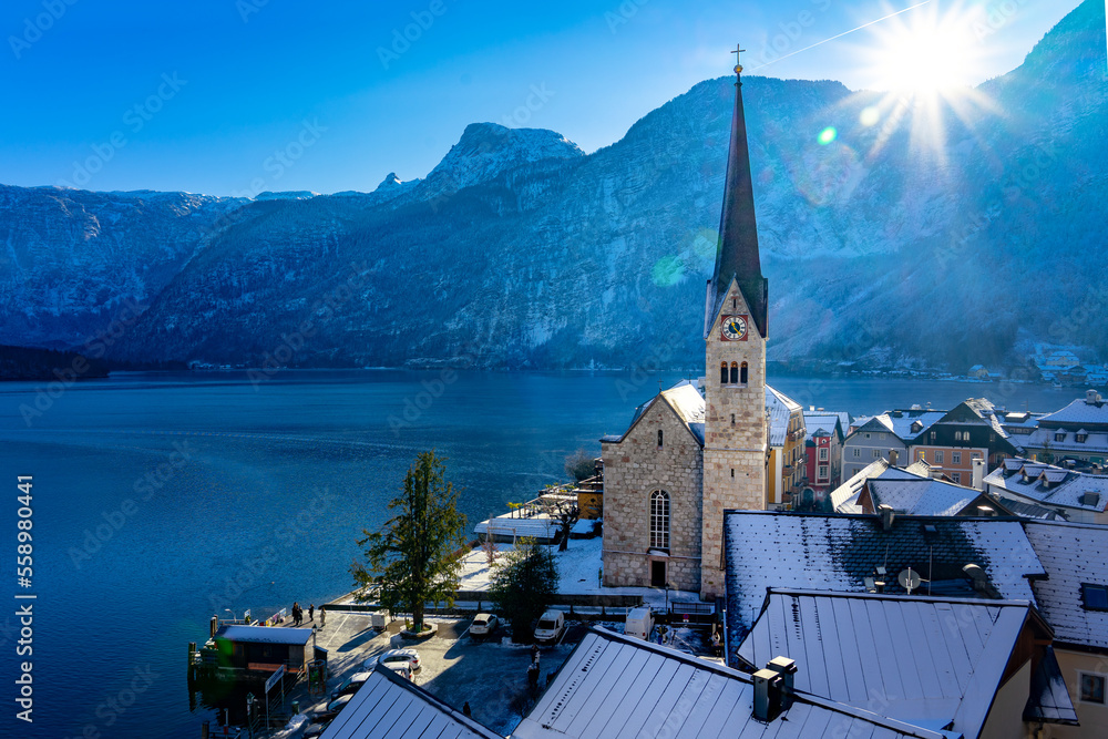 beautiful sunny cityscape of the special city Hallstatt in Austria Salzkammergut snowy winter mountains and lake and church