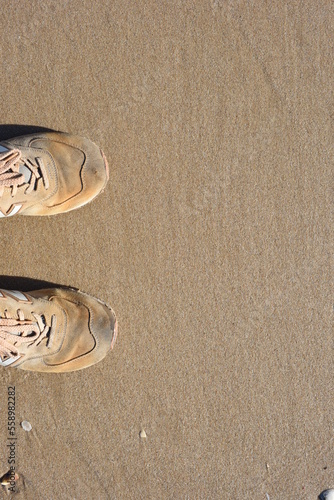 Background created from the sand on the beach with the sneakers.