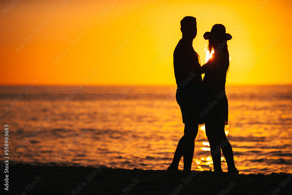 Young couple spending time together on the beach at sunset