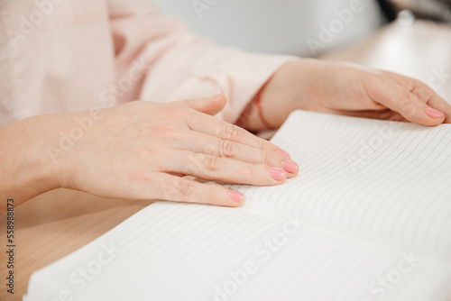 Wallpaper Mural Close up of a woman's hands writing in a notepad placed on a wooden table, home office and work concept, plans and business meeting Torontodigital.ca