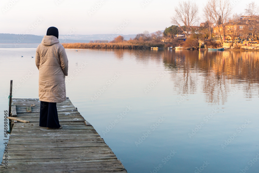 Thoughtful woman looking at lake alone