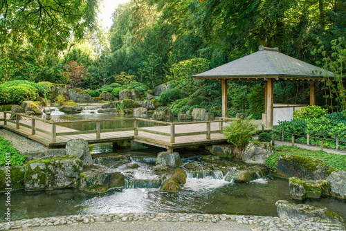 Wooden gazebo and small waterfall in japanese gardenin Botanical garden in Augsburg