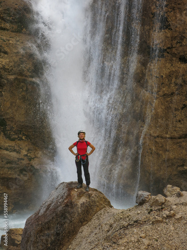 The woman at the waterfall. Trekking in the ferrates of the Dolomites