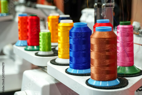 set of multi colored threads of modern electronic professional embroidery machine, Colored thread for sewing, Selective focus.	