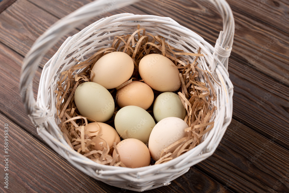 Eggs from purebred chickens with a different shade of shell, eggs from Easter chickens in a white basket Eggs from purebred chickens with a different shade of shell, eggs from Easter chickens in a white basket