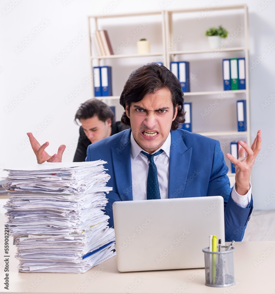 Two male colleagues unhappy with excessive work Two male colleagues unhappy with excessive work