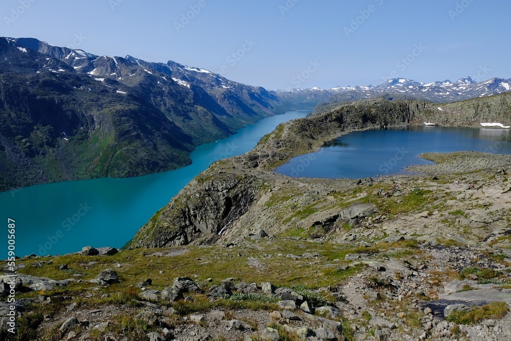 Obraz premium Scenic Besseggen trail in Jotunheimen, Norway - the most beautiful trekking trail in Norway. Silhouettes of hiking tourists on trail.