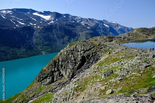 Scenic Besseggen trail in Jotunheimen, Norway - the most beautiful trekking trail in Norway. Silhouettes of hiking tourists on trail.