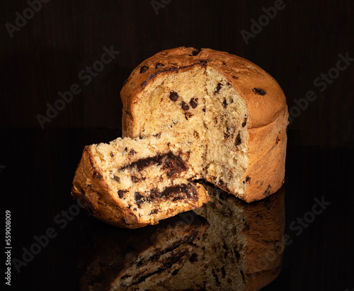Panettone biscuit with chocolate cream on black glass and chocolate filling