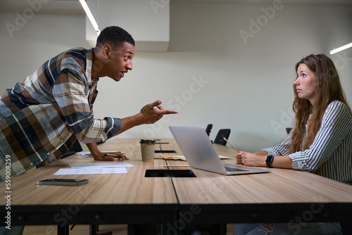 Dissatisfied man arguing with his female colleague in the meeting room