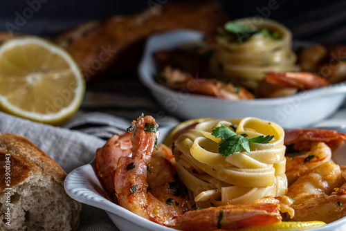 Shrimp scampi served with fettuccini pasta and a crusty baguette