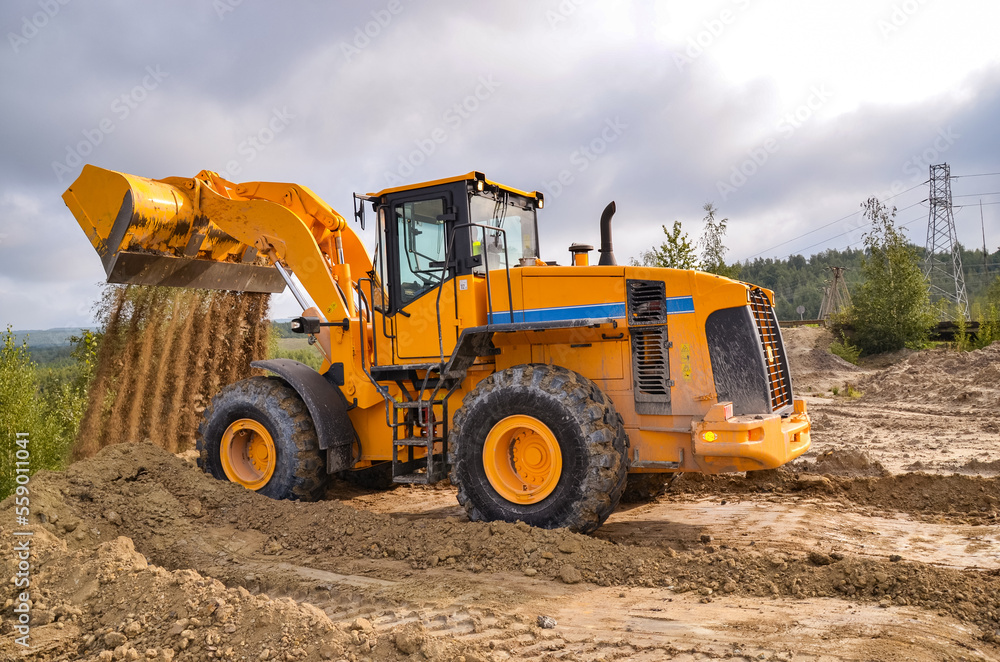 Whell loader working on construction site or quarry. Mining machinery moving clay, smoothing gravel surface for new road. Earthmoving, excavations, digging on soils Whell loader working on construction site or quarry. Mining machinery moving clay, smoothing gravel surface for new road. Earthmoving, excavations, digging on soils