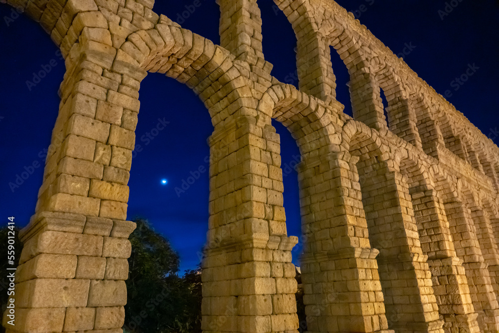 View of the Moon through the arches of the Segovia Aquaduct at night