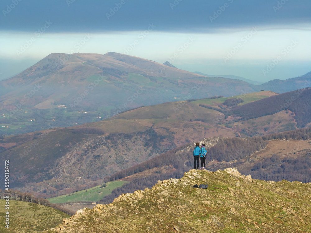 Couple on the crest of a mountain contemplating Gorramendi. Baztan, Navarre