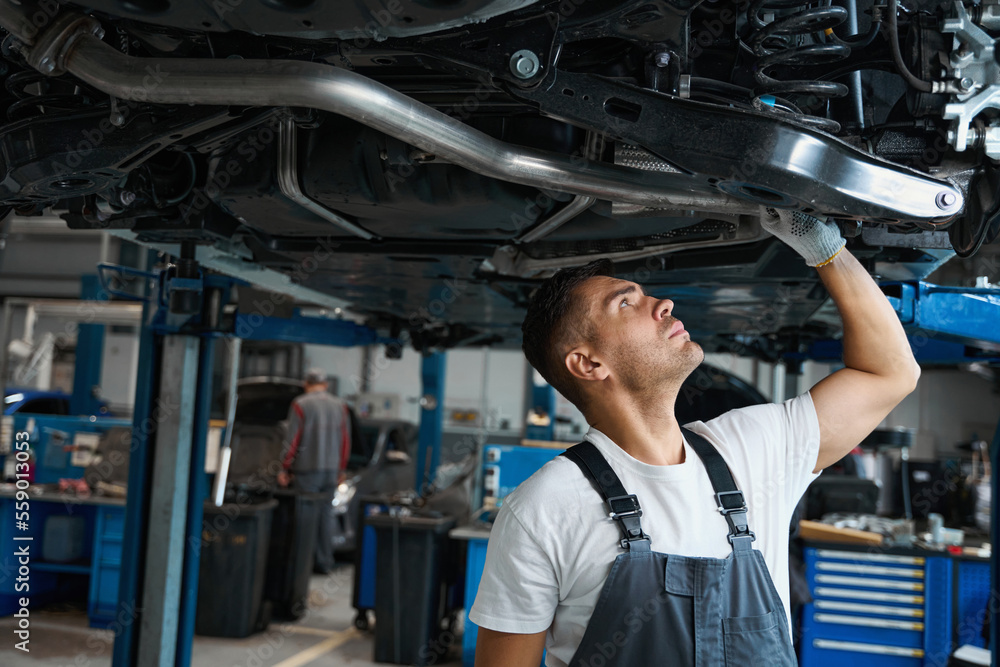 Portrait of man replacing car parts in tire shop Portrait of man replacing car parts in tire shop