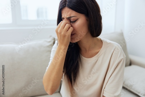 Woman sitting on sofa at home pain in nose and throat, cold and allergy, covid-19 disease, temperature Free Download Woman sitting on sofa at home pain in nose and throat, cold and allergy, covid-19 disease, temperature - GFXLoad