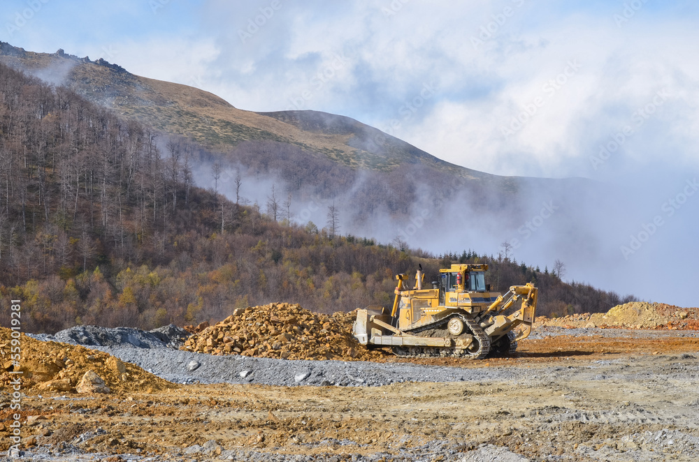 Big crawler dozer working on construction site or quarry. Mining machinery moving clay, smoothing gravel surface for new road. Earthmoving, excavations, digging on soils Big crawler dozer working on construction site or quarry. Mining machinery moving clay, smoothing gravel surface for new road. Earthmoving, excavations, digging on soils