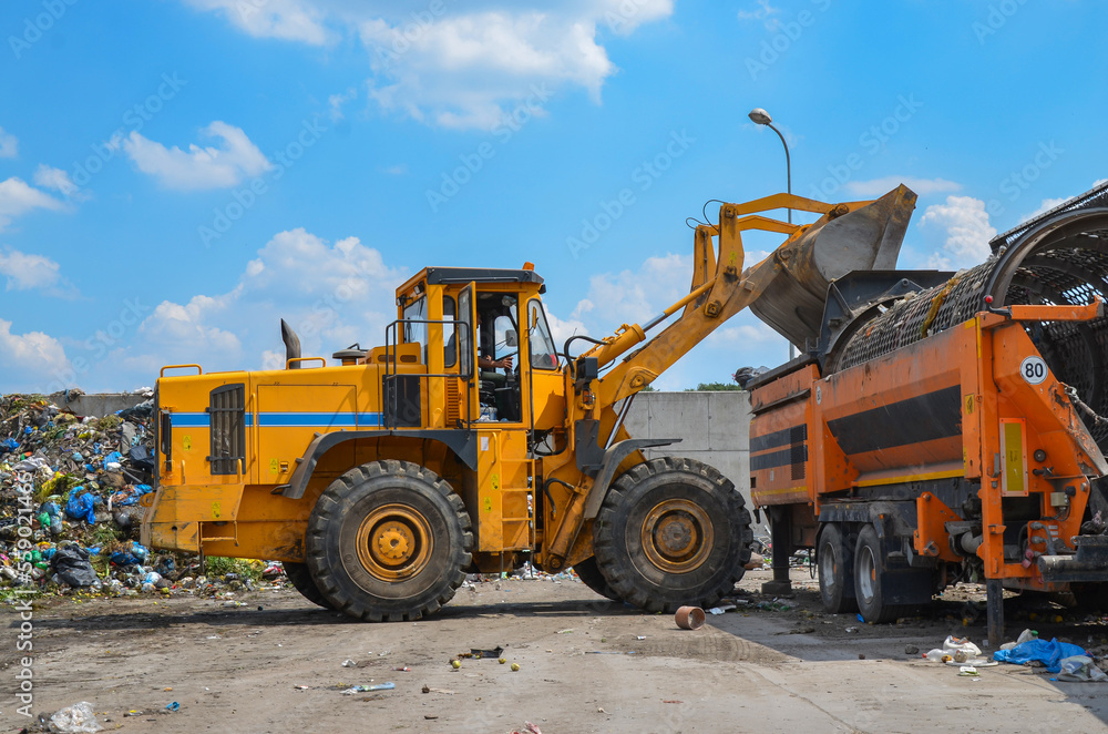 Wheel loader on landfill. Sorting rubbish by wheel loader 