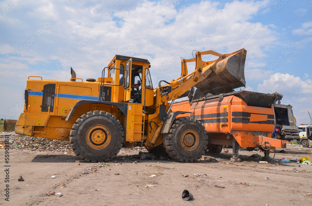 Wheel loader on landfill. Sorting rubbish by wheel loader 