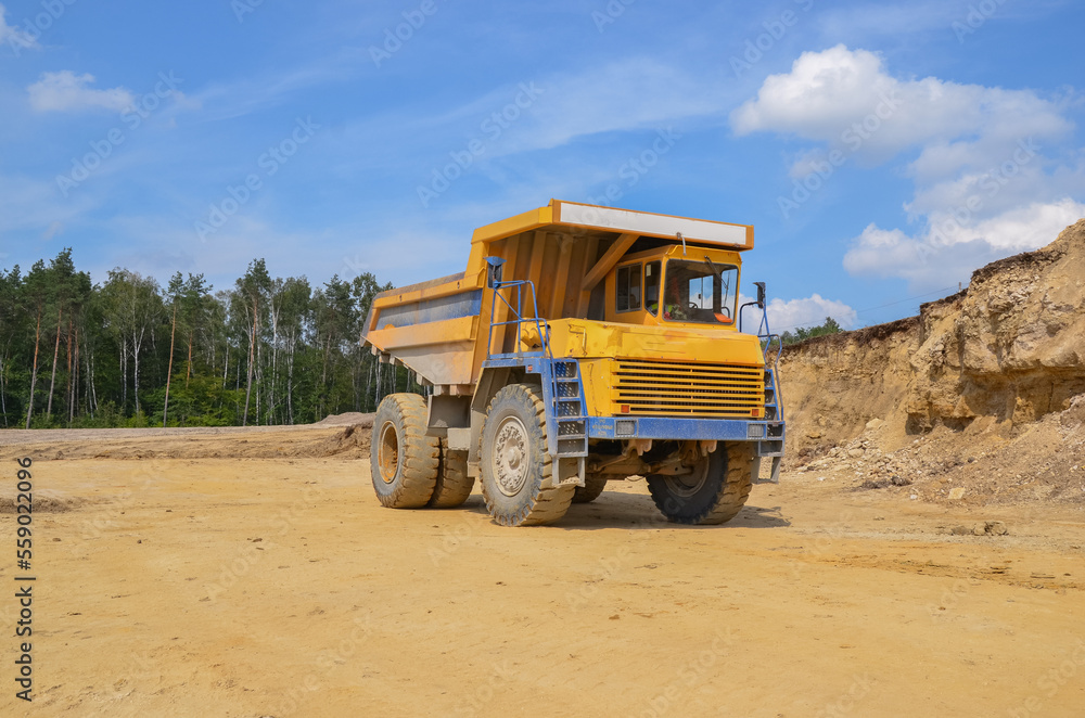 Large dumper truck working in a quarry on bright sunny day