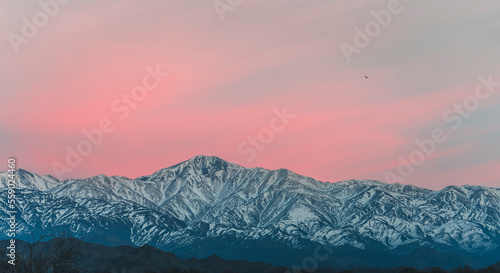 view of the snowy mountain range in the andes with the first lights of