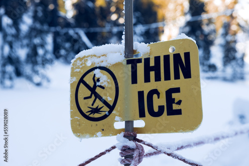 View of warning sign Thin Ice at the Blue Grouse Lake in British Columbia photo