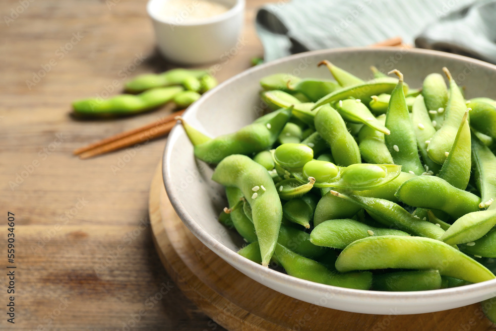 Green edamame beans in pods served on wooden table, closeup. Space for text Green edamame beans in pods served on wooden table, closeup. Space for text