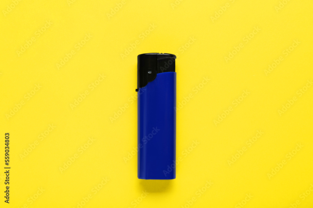 Stylish small pocket lighter on yellow background, top view Stylish small pocket lighter on yellow background, top view