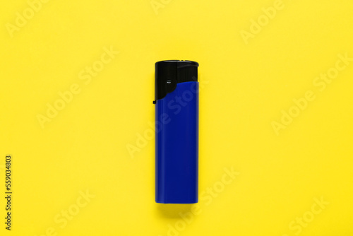 Stylish small pocket lighter on yellow background, top view