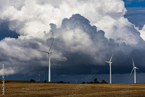 Wind turbines under looming storm clouds