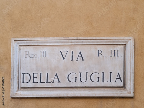 Street sign, "via della Guglia" in Rome, Italy, marble plate on wall.