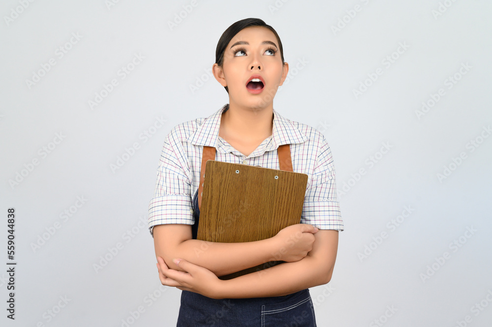 Portrait of young asian woman in waitress uniform pose with clipboard Portrait of young asian woman in waitress uniform pose with clipboard