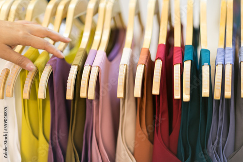 Clothes that are arranged on shelves and hangers