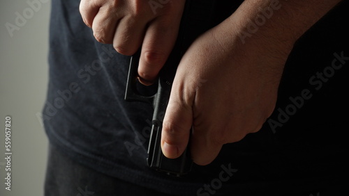 Konstfotografi A man cocking a pistol, to cock  hammer back ready to fire.
