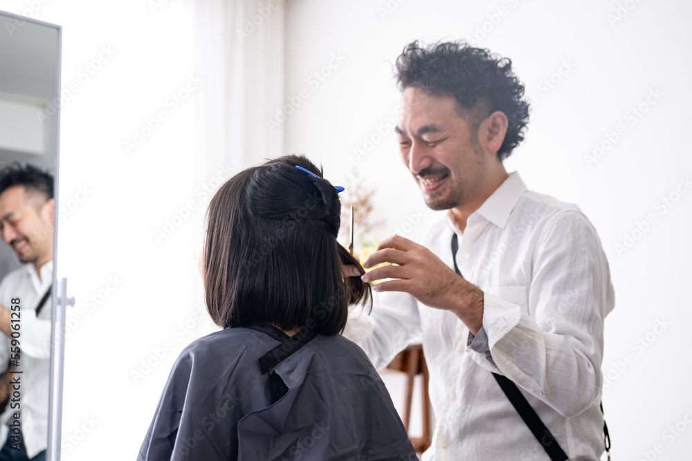 A hairdresser is cutting a child's hair. A hairdresser is cutting a child's hair.