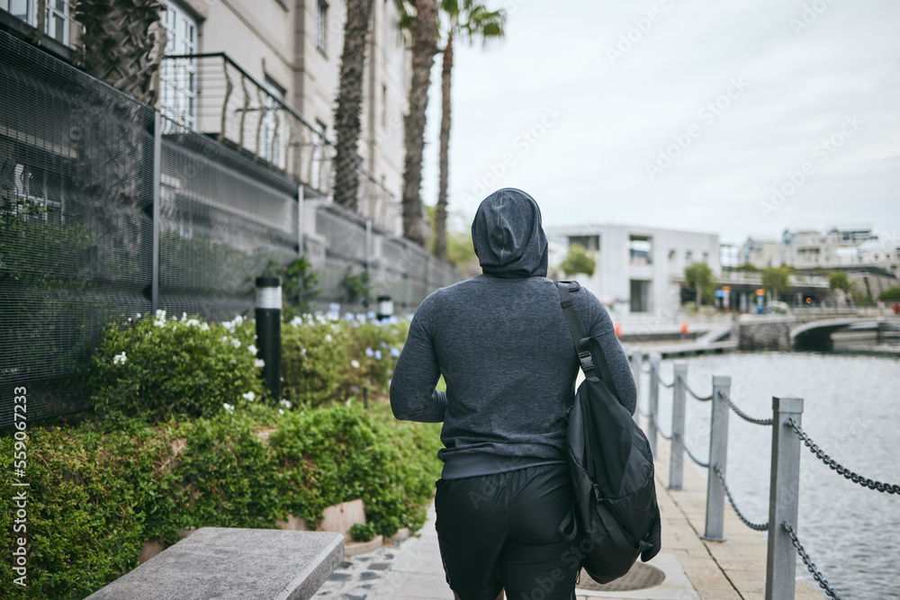 Fitness, hoodie or man walking to gym for body training, exercise or workout with a duffle bag in Miami, Florida. City, mindset or healthy sports athlete with wellness goals, motivation or mission Fitness, hoodie or man walking to gym for body training, exercise or workout with a duffle bag in Miami, Florida. City, mindset or healthy sports athlete with wellness goals, motivation or mission