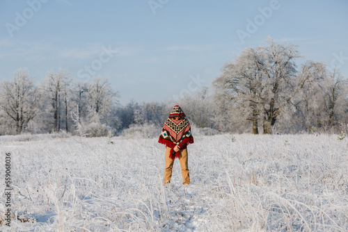 a man in a winter forest, alone in a poncho, a walk in nature
