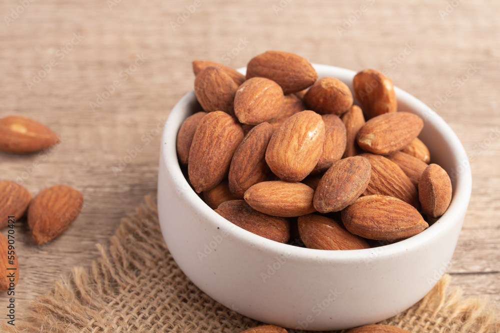 Salted almonds in a white cup.Copy space. Salted almonds in a white cup.Copy space.